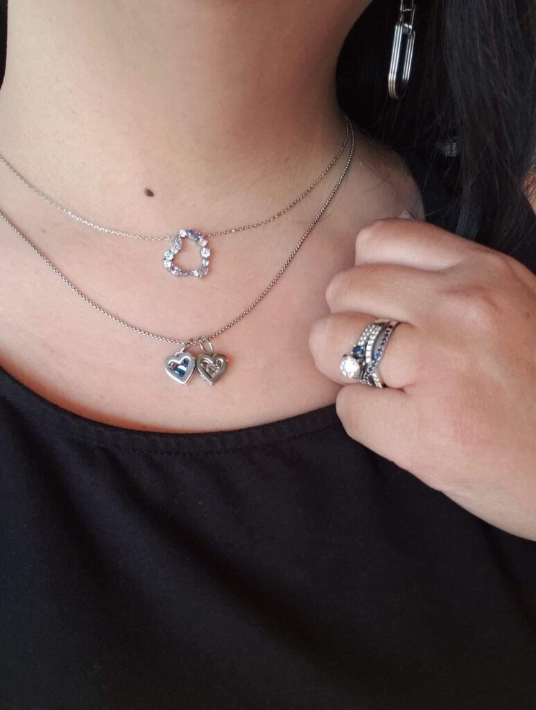 Woman wearing heart pendant and 2 birthstone hearts