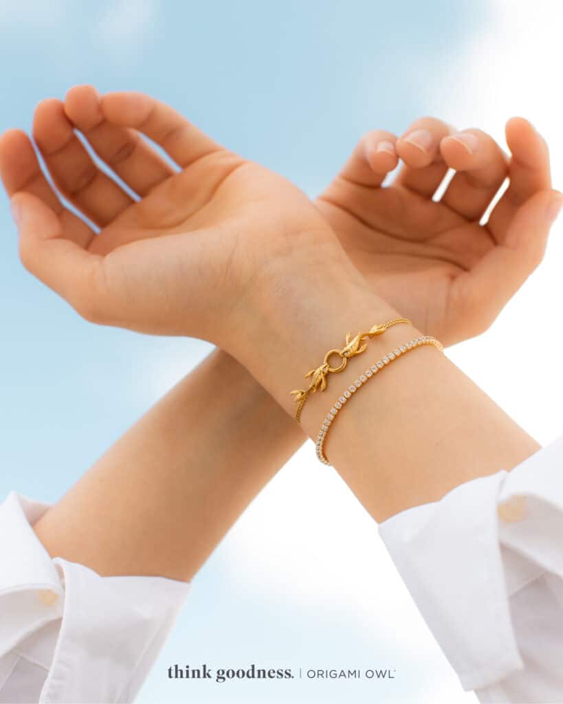 A woman’s arms cross with the sky in the background wearing an origami owl persevere Bolo bracelet