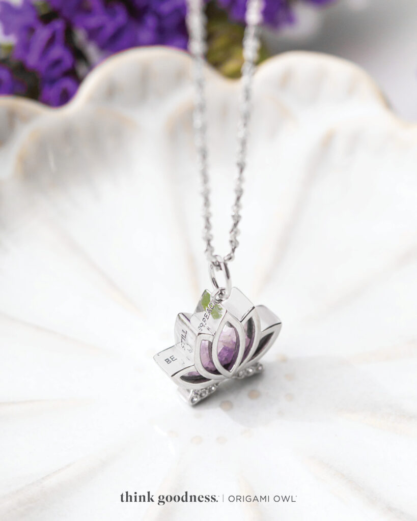 A white shell with a lotus capsule locket with crystals on a chain