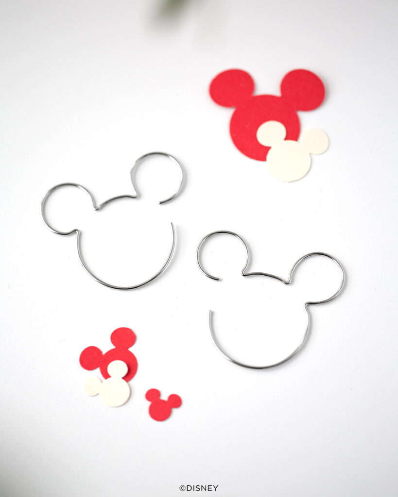 Silver Mickey Mouse threader hoops ona white image with Mickey ear puzzle pieces in red and white