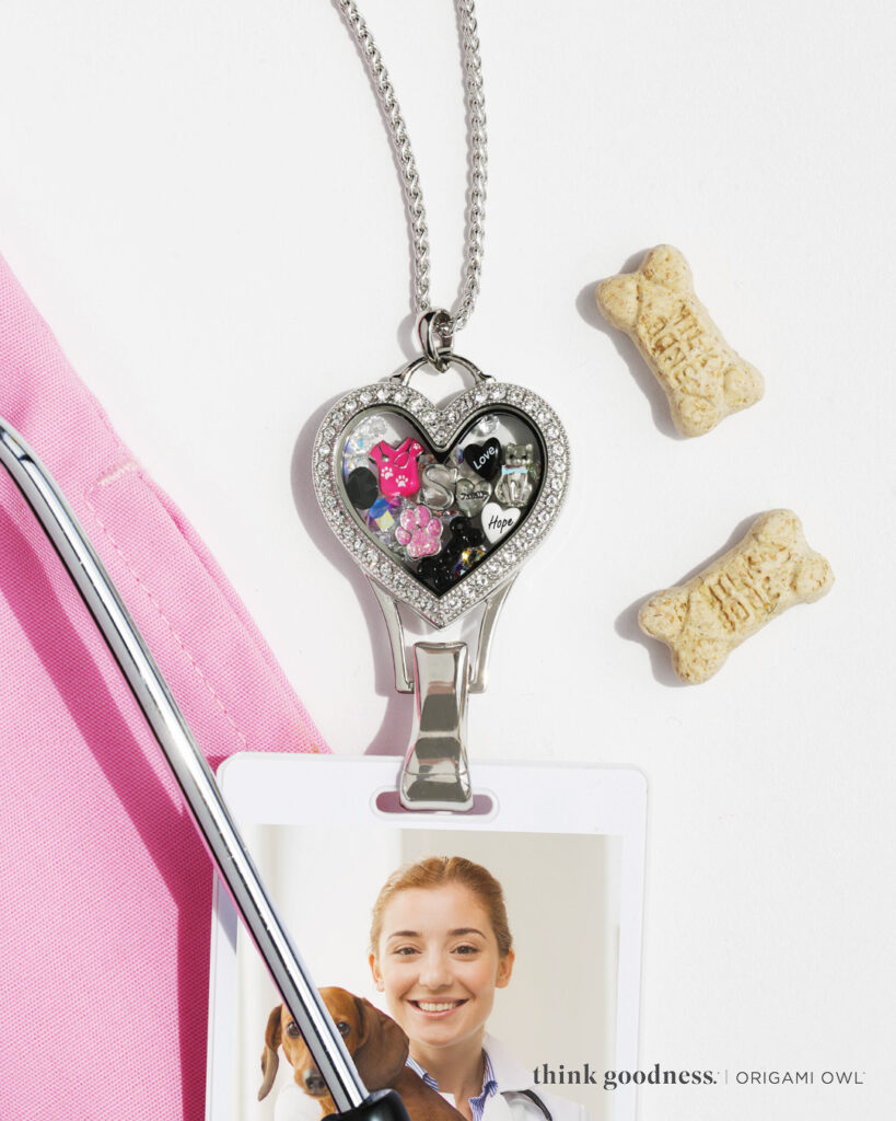 A silver heart lanyard locket with a pink heart paw, a pink scrub, top and black heart 