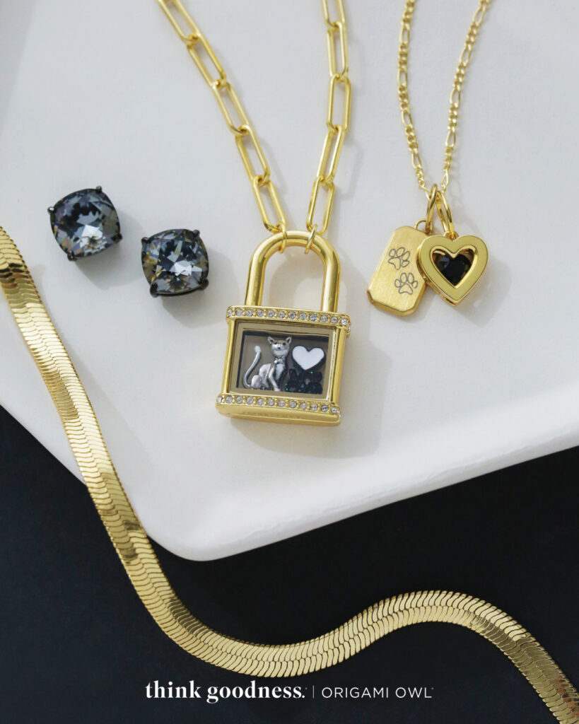 A gold snake chain, black Clara crystal studs and a gold Lock locket with black bone charm and a gold birthstone heart with a black crystal 