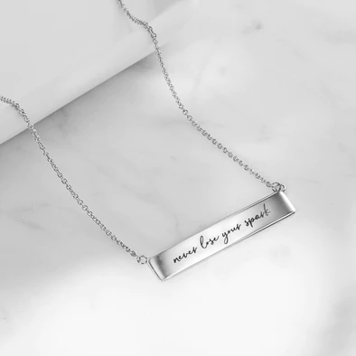 Horizontal bar locket in silver that says never lose your spark