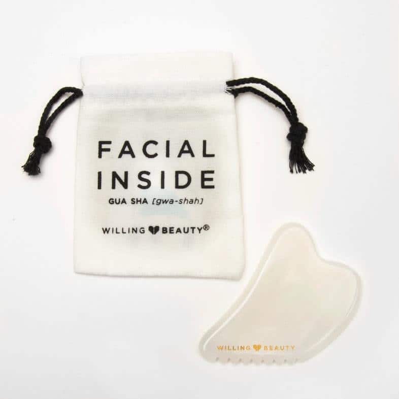 a white image with a willing beauty gua sha facial tool and a canvas storage bag that says facial inside GUA SHA (gwa-shah) Willing Beauty