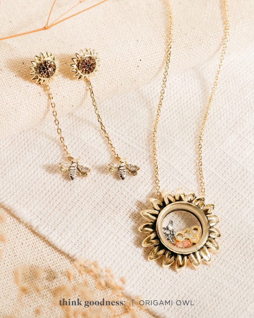 an off white image with some beige foliage showing the Origami Owl Sunflower Capsule Locket and the Sunflower and Bee Drop Earrings 