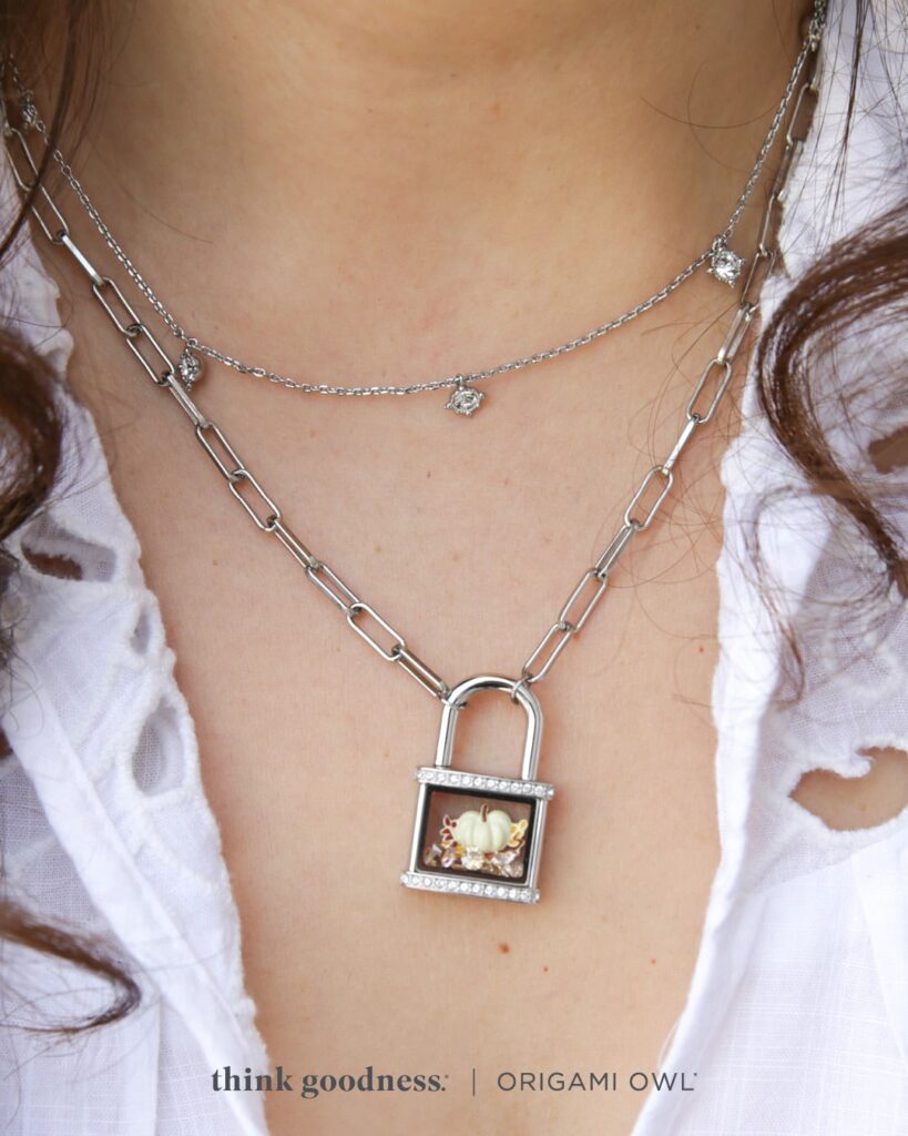 an image of a woman's neckline wearing the crystal padlock living locket necklace and a necklace with crystal dangles