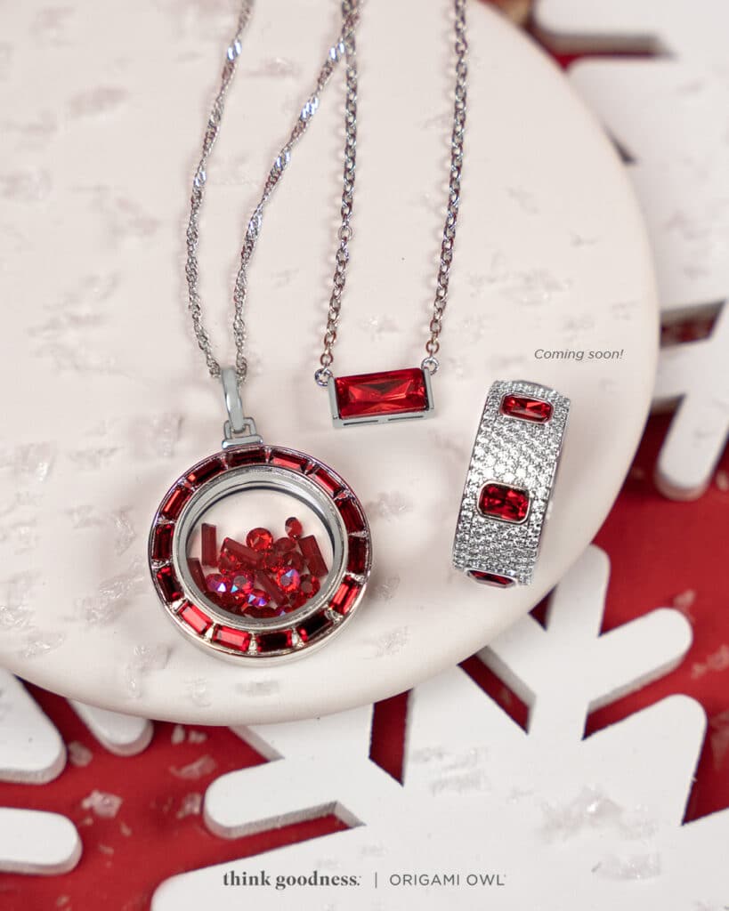 a red back ground with white snowflakes and a round platter showing the siam crystal baguette locket, fierce baguette pendant necklace and siam crystal pave ring. All adorned with red baguettes