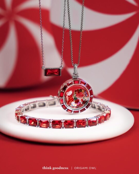 a red background with a round white plate showing the siam baguette tennis bracelet, siam crystal baguette locket and fierce baguette pendant necklace