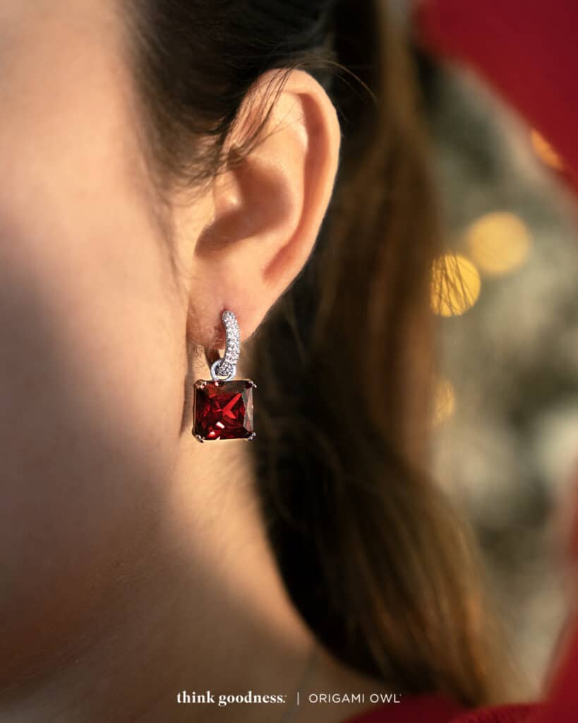 the side of a womans head showing the siam drop crystals with a red baguette