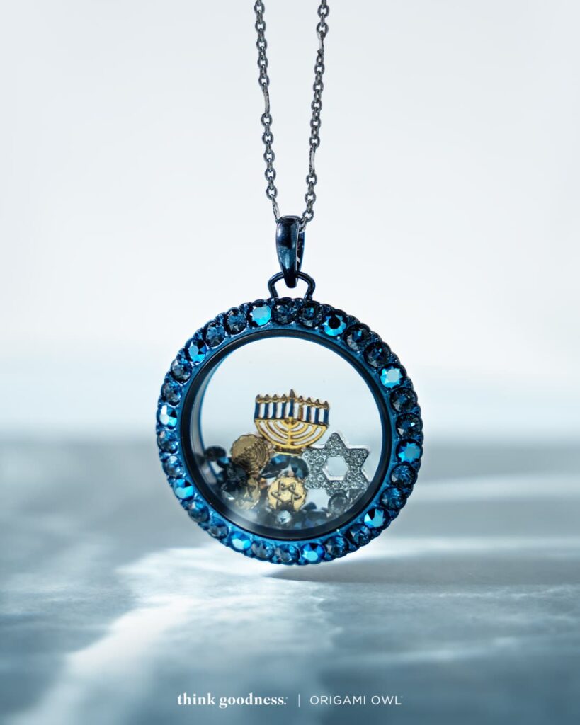 an abstract blue image showing the new blue shimmer large living locket on a chain with stardust, star of david and gold menorah charms