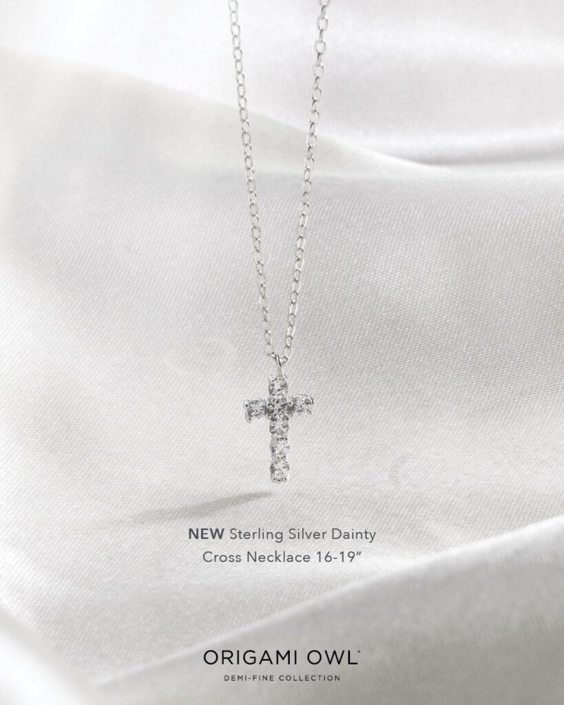 A light abstract background with a Demi fine dainty silver cross necklace